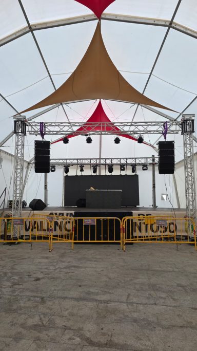 Escenario al aire libre con telones y equipos de sonido, listo para un evento.