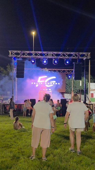 Eventos al aire libre con escenario iluminado y público disfrutando de un espectáculo nocturno.